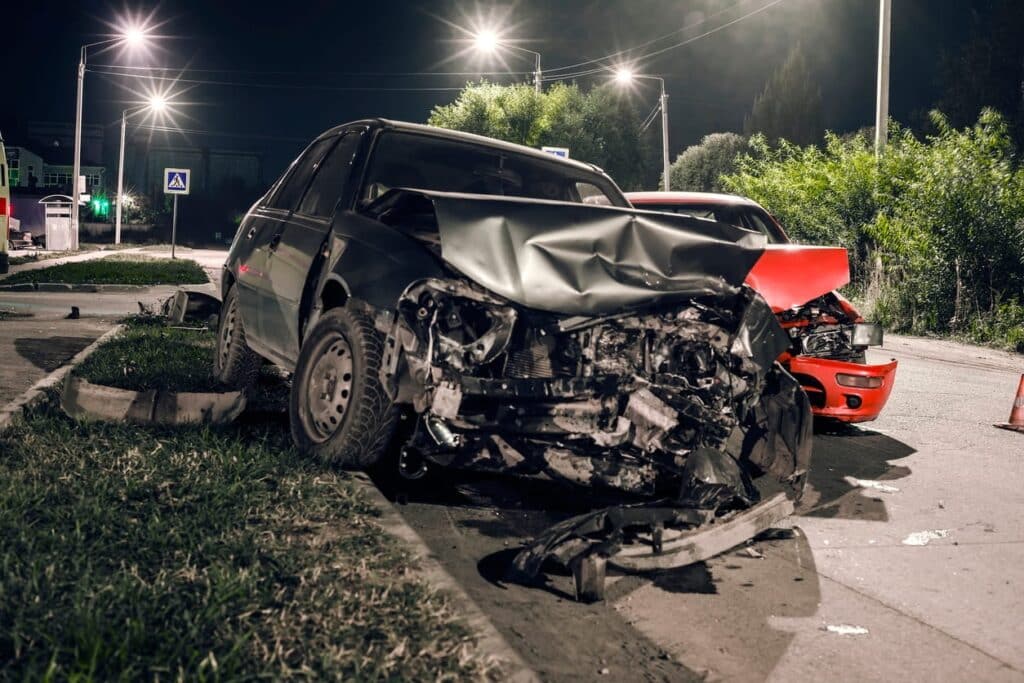 A severely damaged black vehicle after a drunk driving accident.