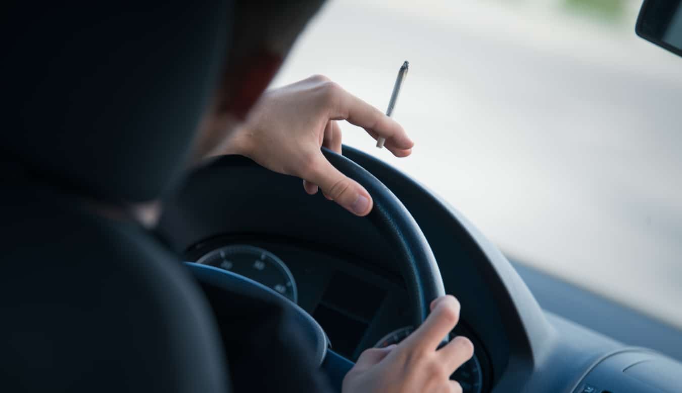 Man driving while smoking a marijuana joint