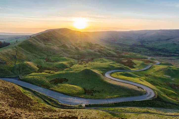 Sunset over winding road in hills