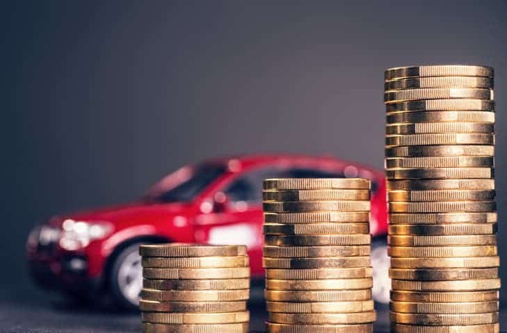 Stacks of coins increasing in size in front of toy car