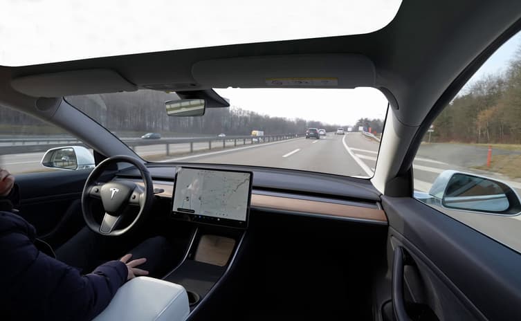 Man in self-driving Tesla car on the highway or interstate