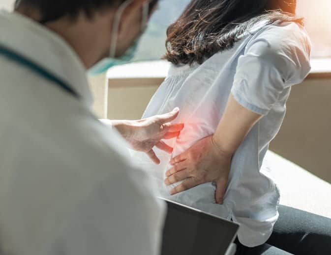 A doctor examining a back injury on a patient after a car accident.