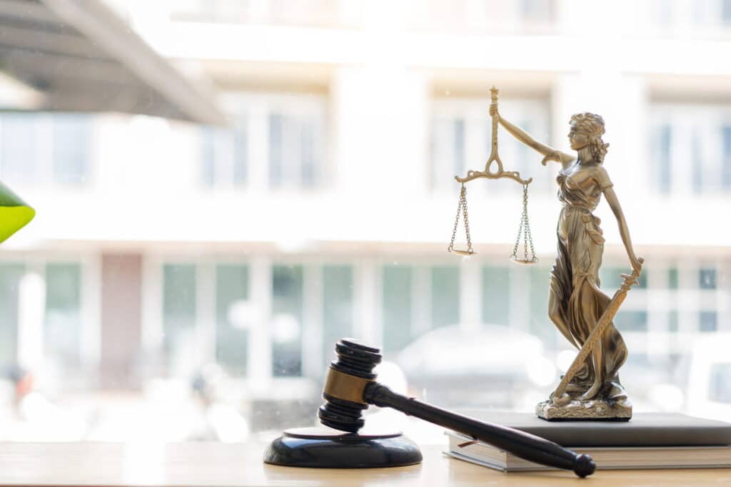 A Lady Justice statue, a stack of books, and a gavel on a Tampa boating accident attorney's desk.