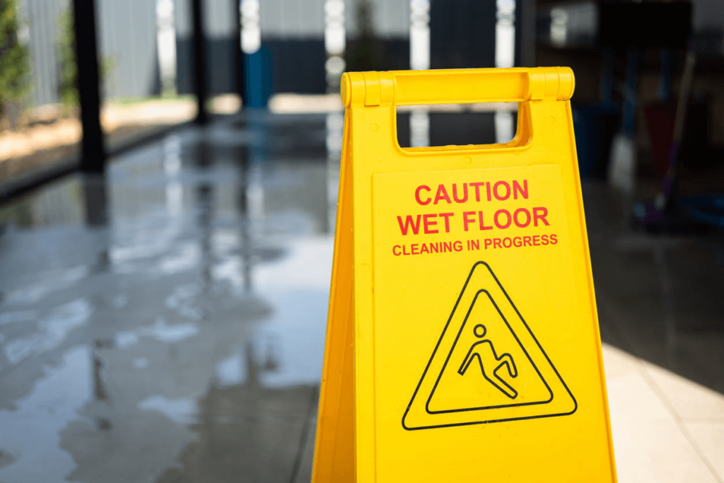 A yellow caution: wet floor sign regarding a premise liability case.