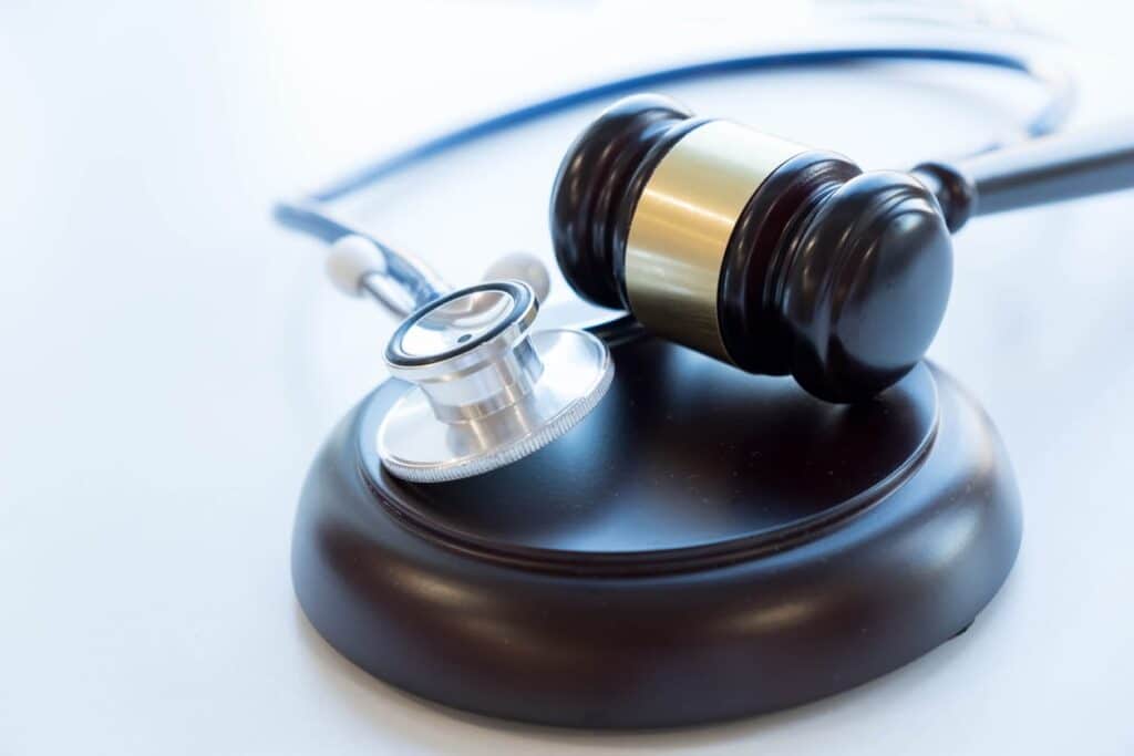 A stethoscope resting next to a gavel regarding a medical malpractice case.