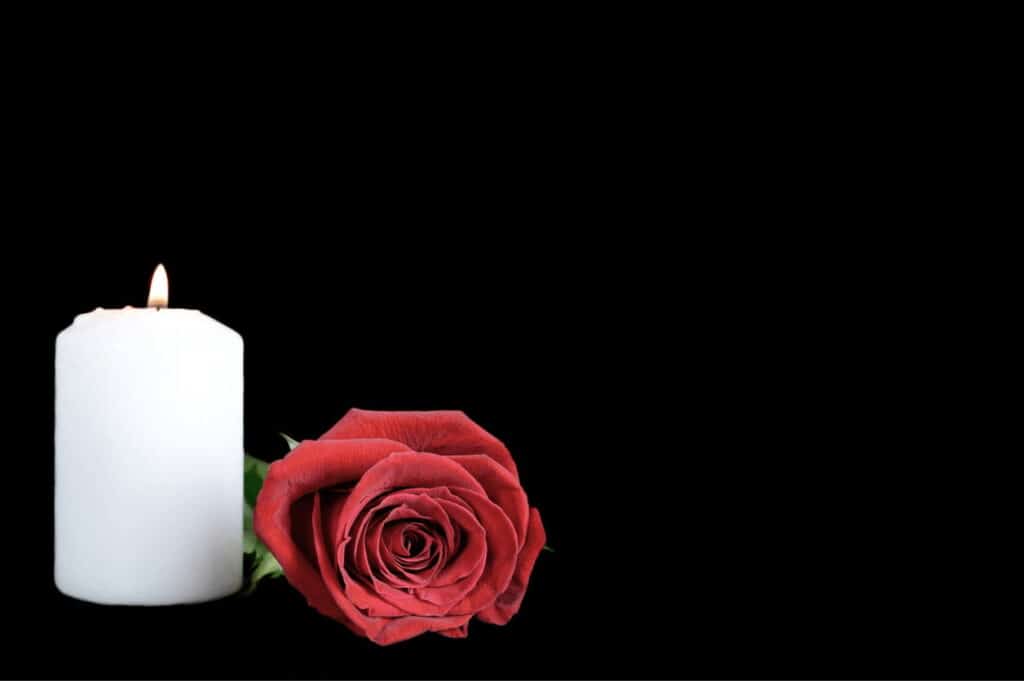 A rose and candle in memory of someone who died to to a wrongful death