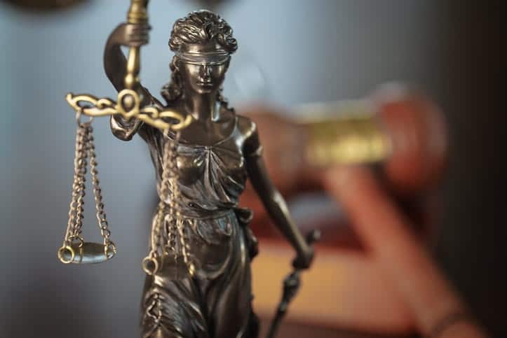A closeup of a Lady Justice statue on a motorcycle accident attorney's desk. 