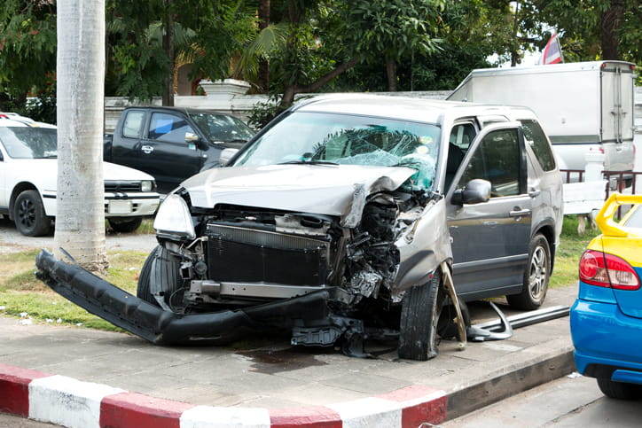 A car crash scene with a severely damaged car