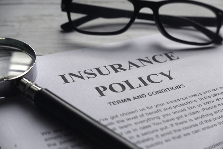 An insurance policy with glasses and a magnifying class 
