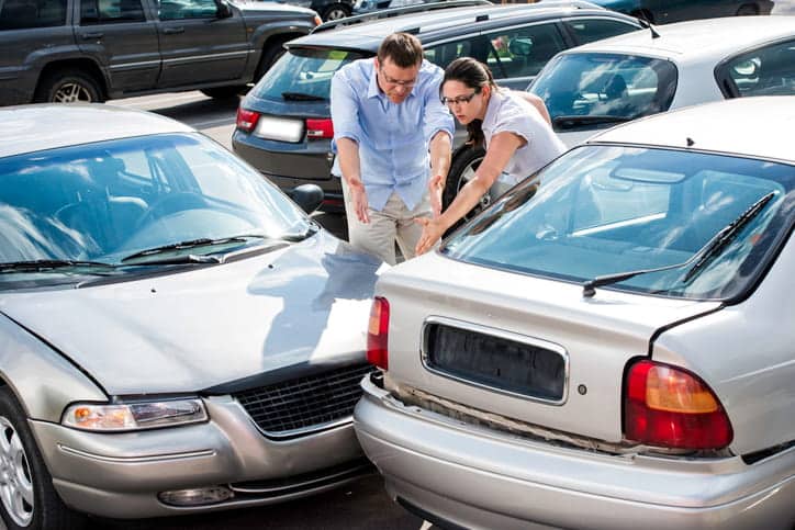 A parking lot car accident with a man and a woman arguing over fault