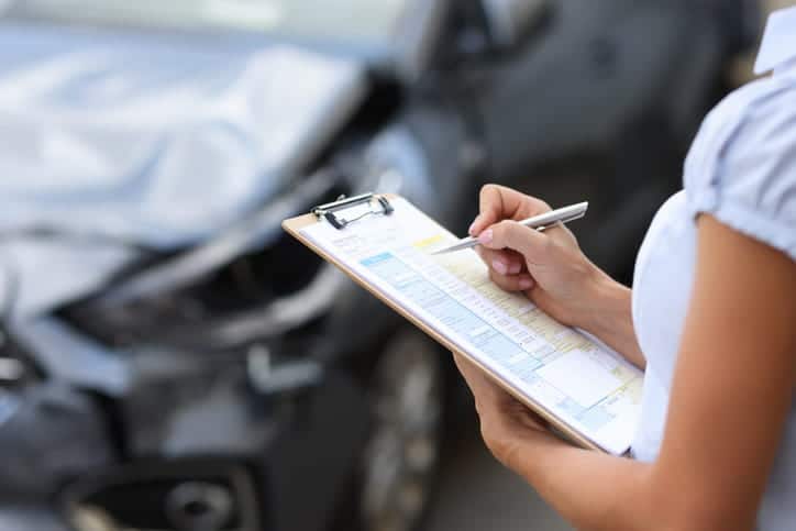 An Insurance Agent Reporting On The Damage Of A Vehicle After An Accident To Determine Fault.