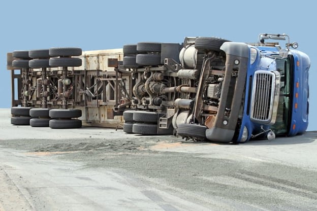 Clearwater Truck Accident Lawyer 1 A Truck Accident Scene Showing An Overturned Blue Semi-Trailer With Its Trailer Detached On A Road, Highlighting Severe Damage.