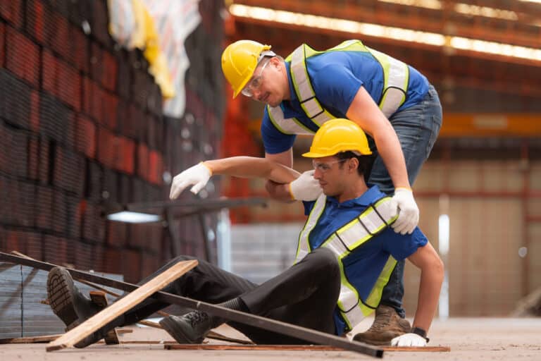 Injured Construction Worker Receiving Help After A Slip And Fall Accident